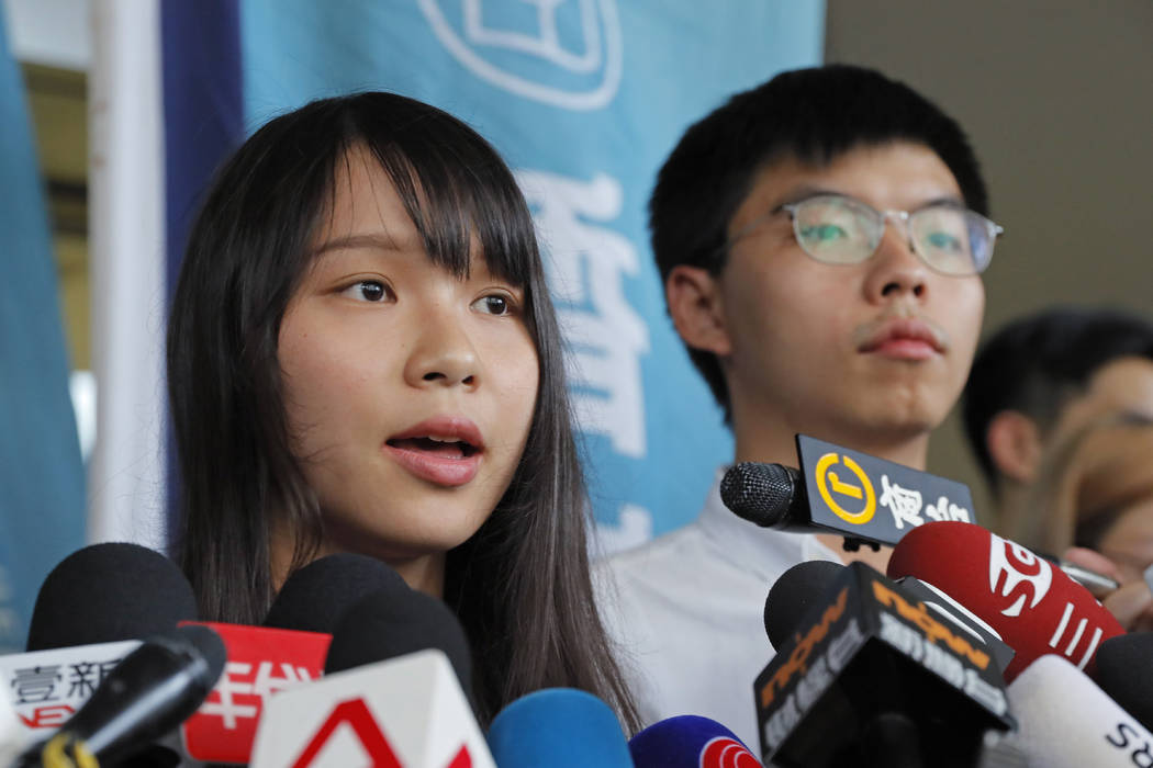 Pro-democracy activists Joshua Wong, right, and Agnes Chow speak to media outside a district co ...