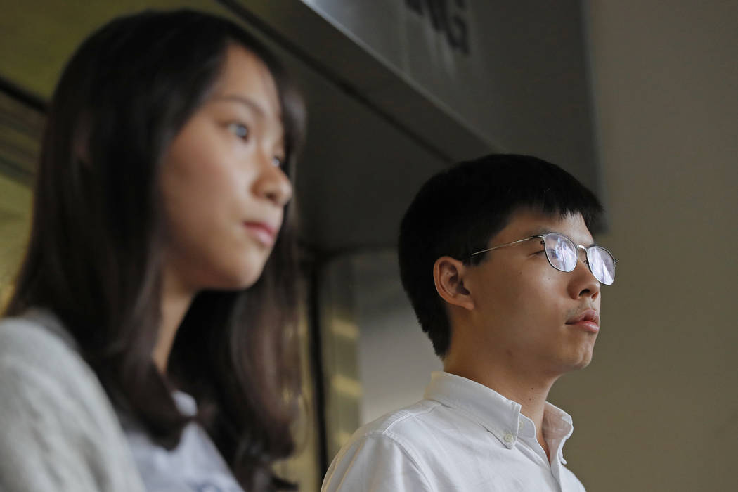 Pro-democracy activists Joshua Wong, right, and Agnes Chow speak to media outside a district co ...
