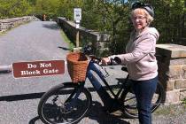 In a June 8, 2019, file photo, Janice Goodwin stands by her electric-assist bicycle at a gate n ...