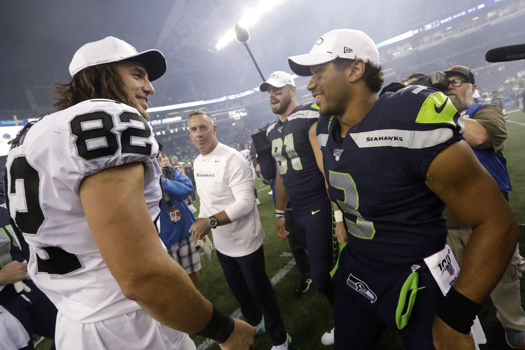 Seattle Seahawks quarterback Russell Wilson, right greets a former teammates, Oakland Raiders t ...