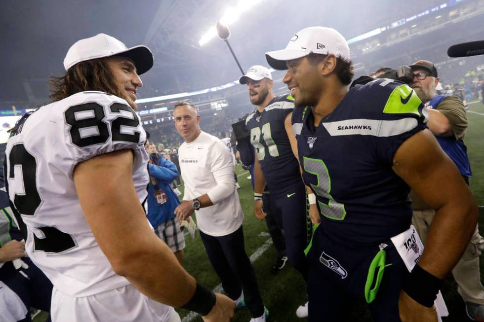 Seattle Seahawks quarterback Russell Wilson, right greets a former teammates, Oakland Raiders t ...