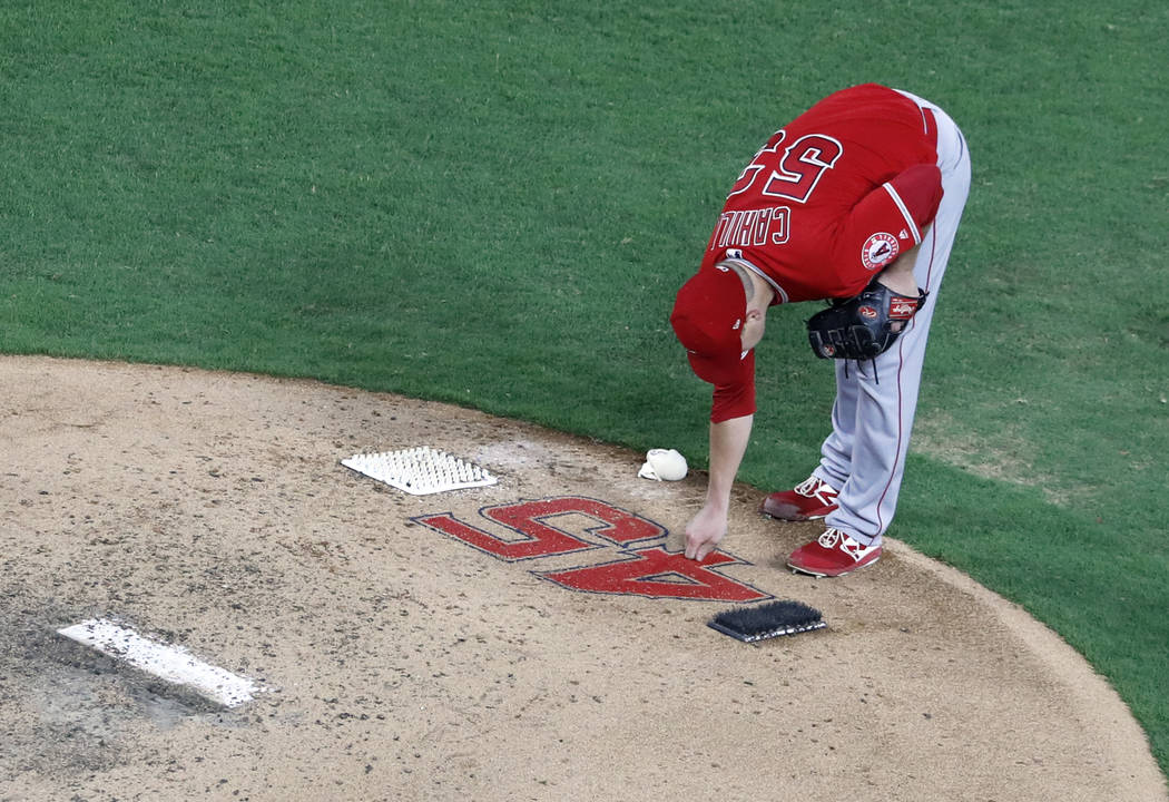 Los Angeles Angels starting pitcher Trevor Cahill (53) reaches down to touch the number 45 on t ...