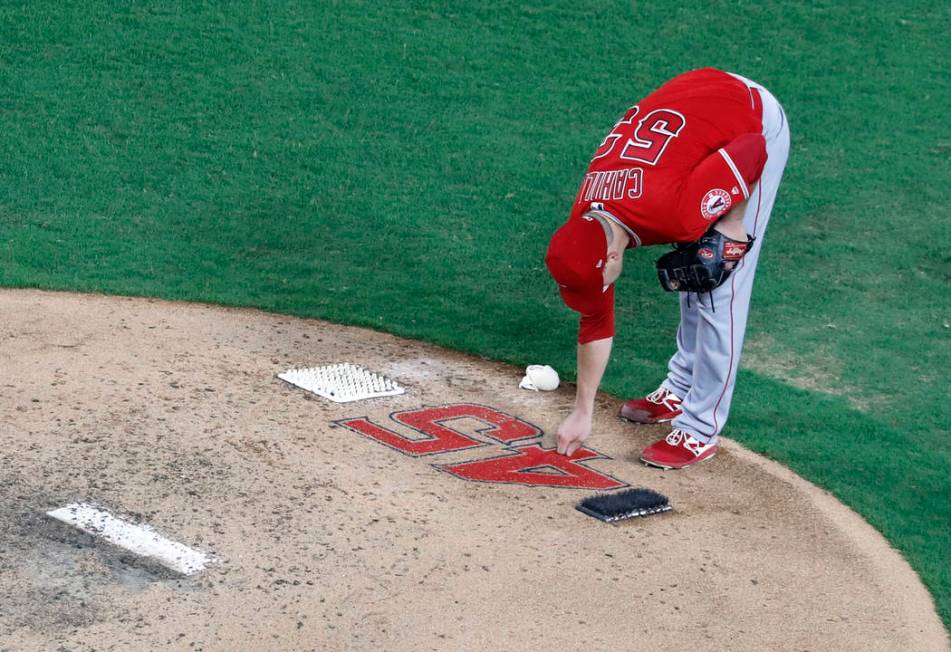 Los Angeles Angels starting pitcher Trevor Cahill (53) reaches down to touch the number 45 on t ...