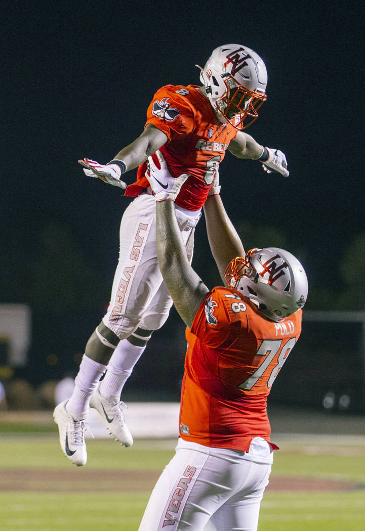 UNLV Rebels running back Charles Williams (8) is hoisted by UNLV Rebels offensive lineman Justi ...