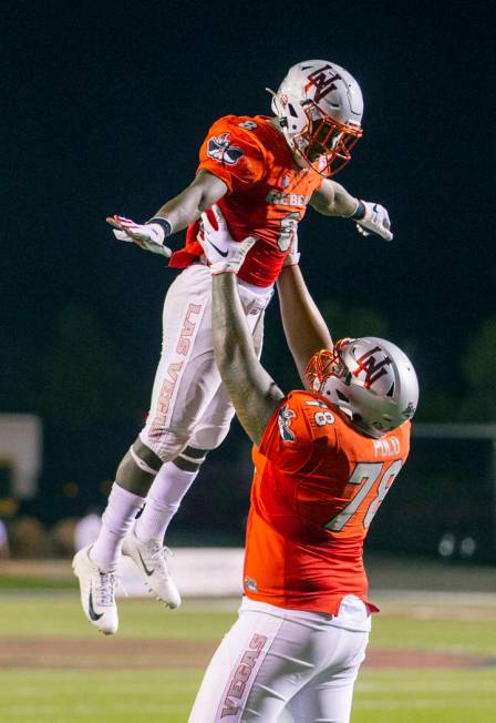 UNLV Rebels running back Charles Williams (8) is hoisted by UNLV Rebels offensive lineman Justi ...