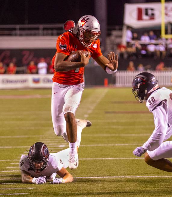 UNLV Rebels quarterback Armani Rogers (1) leaps over Southern Utah Thunderbirds safety AJ Stanl ...