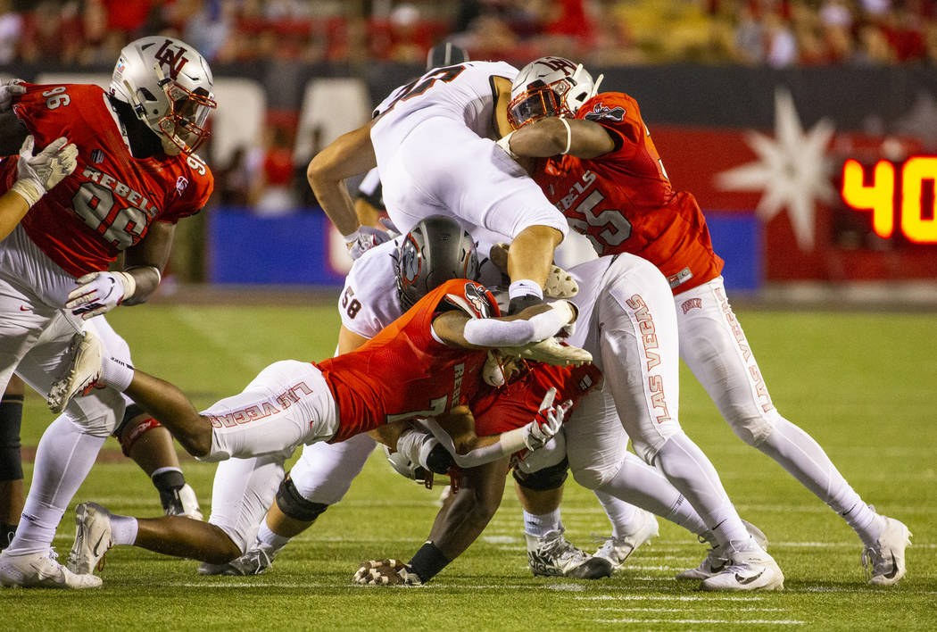 UNLV Rebels defenders tackle Southern Utah Thunderbirds running back James Felila (23) during t ...