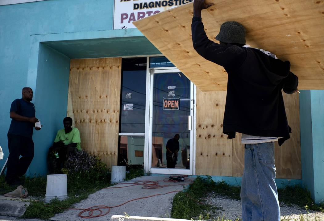 Workers board up a shop’s window front as they make preparations for the arrival of Hurr ...