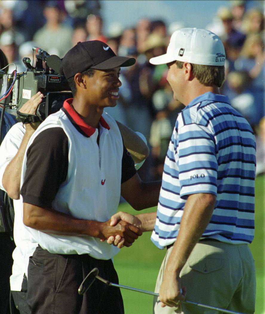 Tiger Woods, left, is congratulated by Davis Love III after he defeated Love on the first playo ...