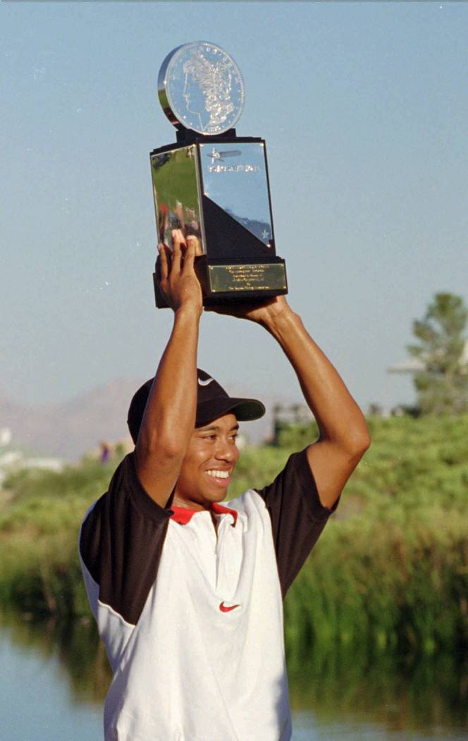 Rookie pro golfer Tiger Woods proudly displays his trophy for winning the Las Vegas Invitationa ...