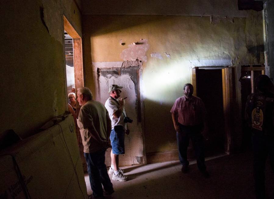 Steve Helt of Las Vegas, center, shines a flashlight while touring the Goldfield Hotel during t ...