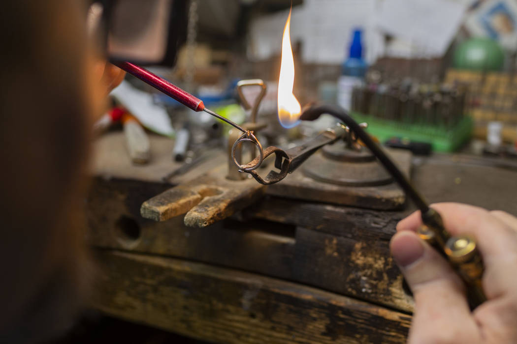 Gold Casters Jewelry owner Michael Holland prepares a wedding ring to be set in his workshop at ...