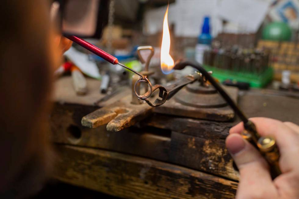 Gold Casters Jewelry owner Michael Holland prepares a wedding ring to be set in his workshop at ...