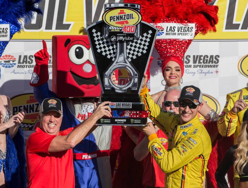 Joey Logano, right, and Carlos Maurer, president of Shell Lubricants Americas, hold the first p ...