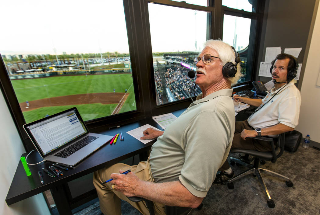 Jerry Reuss, left, and Russ Langer look to a video replay for their radio broadcast during the ...