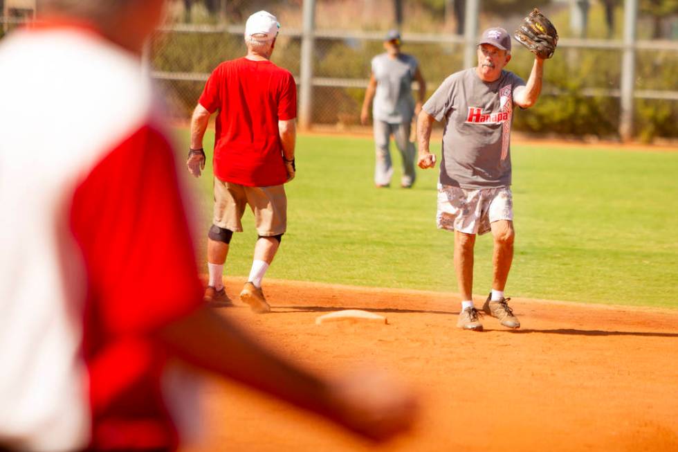 George Fernandez, 76, signals to the pitcher after he makes a catch at Lorenzi Park on Tuesday, ...