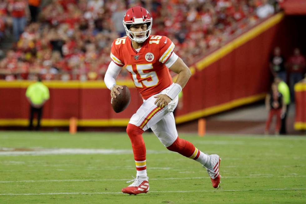 Kansas City Chiefs quarterback Patrick Mahomes (15) scrambles during the first half of an NFL p ...