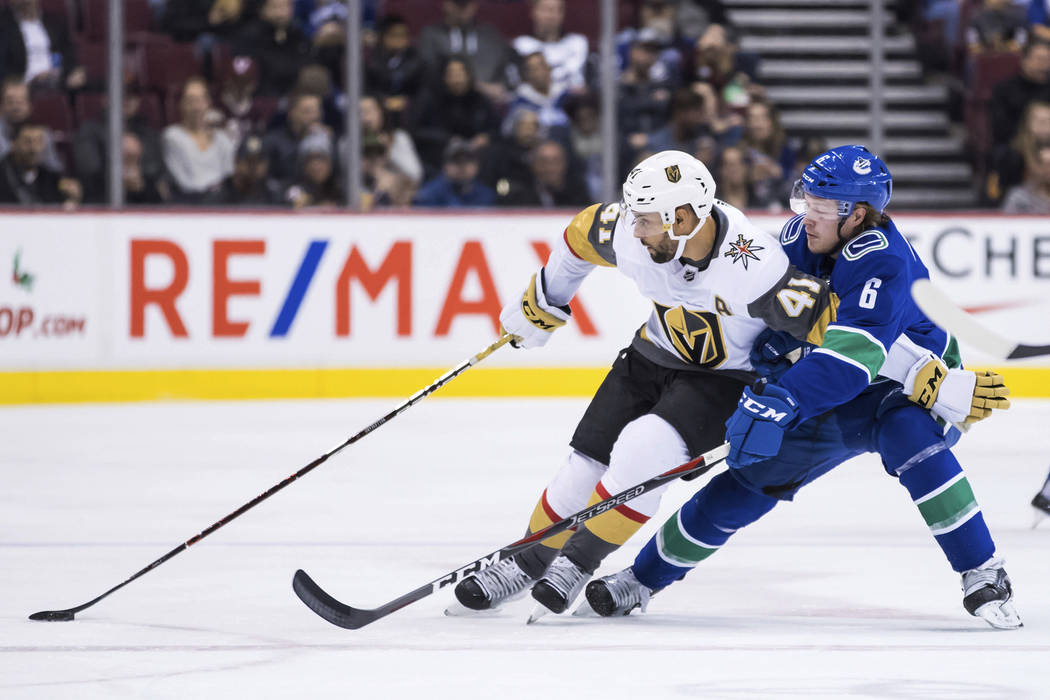 Vegas Golden Knights' Pierre-Edouard Bellemare (41) tries to hold off Vancouver Canucks' Brock ...