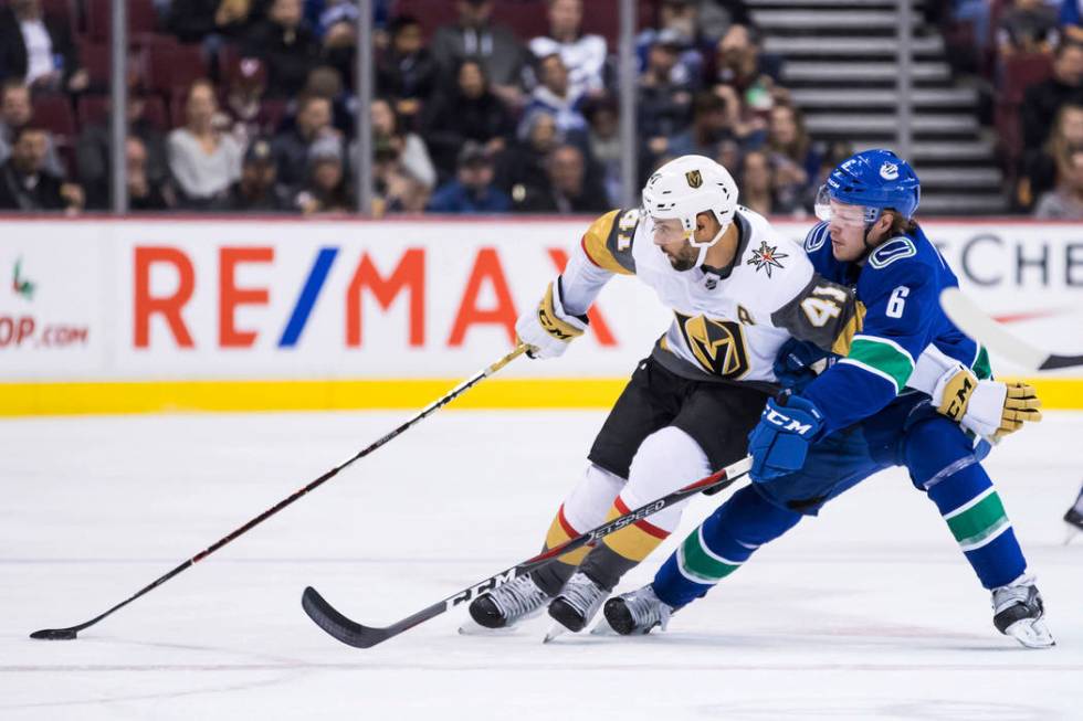 Vegas Golden Knights' Pierre-Edouard Bellemare (41) tries to hold off Vancouver Canucks' Brock ...