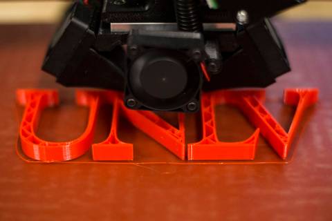 A 3D printer creates a UNLV plastic logo at the new Makerspace in the Lied Library at UNLV in L ...