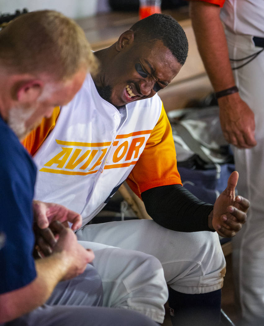 Las Vegas Aviators shortstop Jorge Mateo (14) winces in pain while being checked out by the tra ...