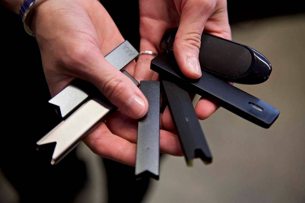 A researcher holds vape pens in a lab at Portland State University in in Portland, Ore. Nevada ...