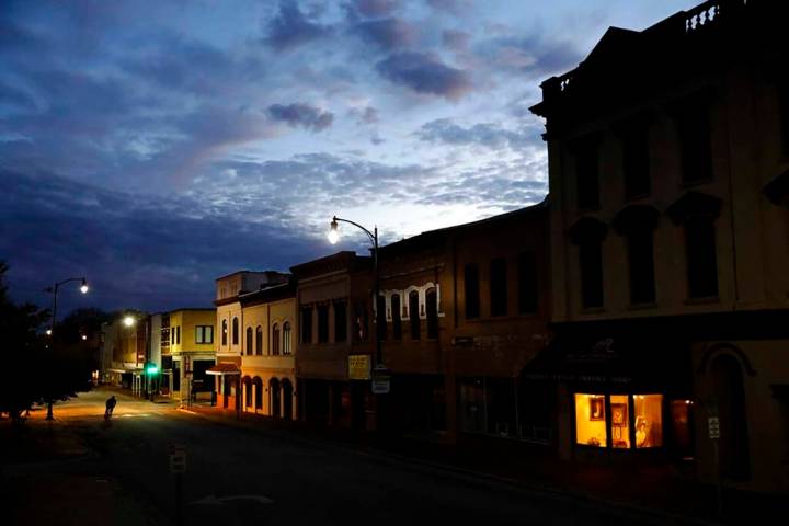 In an Oct. 28, 2017, file photo, the storefront window of a portrait studio is lit up along a d ...