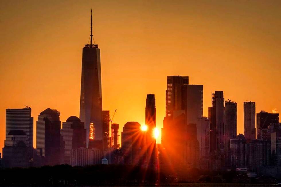 In a July 1, 2019, file photo, the sunlight flares around the buildings in lower Manhattan as t ...