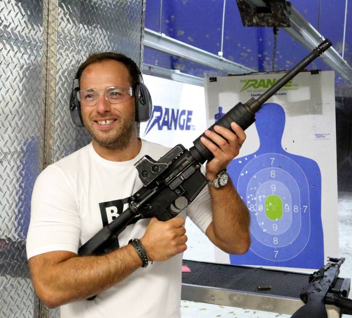 Lee Goldsmith, 39, of Liverpool, England, holds up an M4 assault rifle after firing it at The R ...