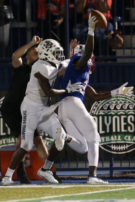 Lberty's Germie Bernard (2) makes a catch under pressure from St. John Bosco's James Smith (4) ...