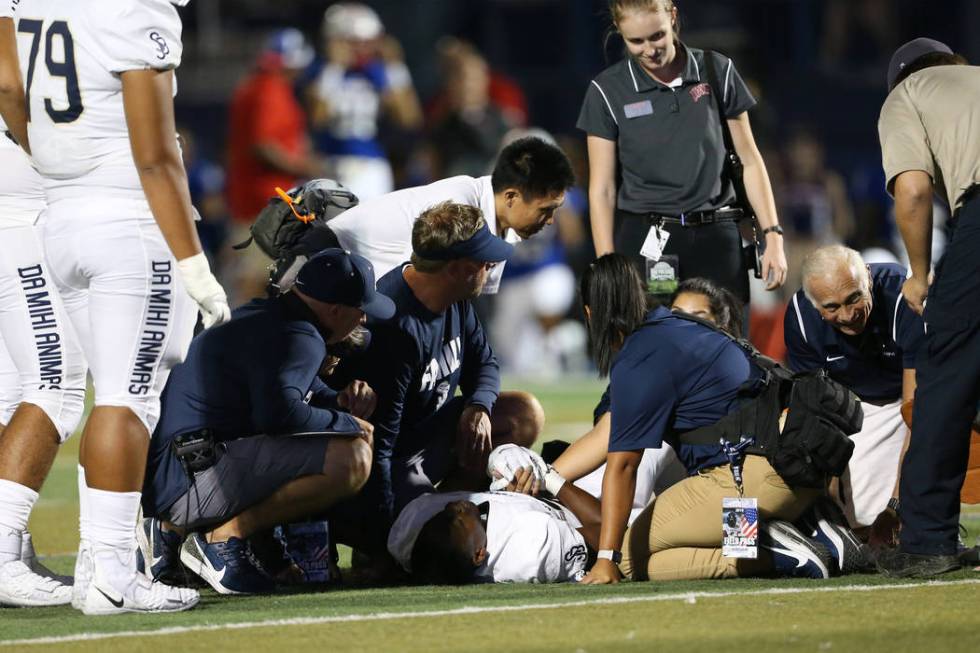 St. John Bosco's Michael Hayes (28) receives medical attention after a play against Liberty in ...