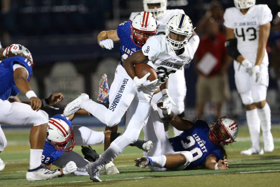 St. John Bosco's Michael Hayes (28) runs the ball against Liberty's Jayden Rookhuyzen (45), Tr ...