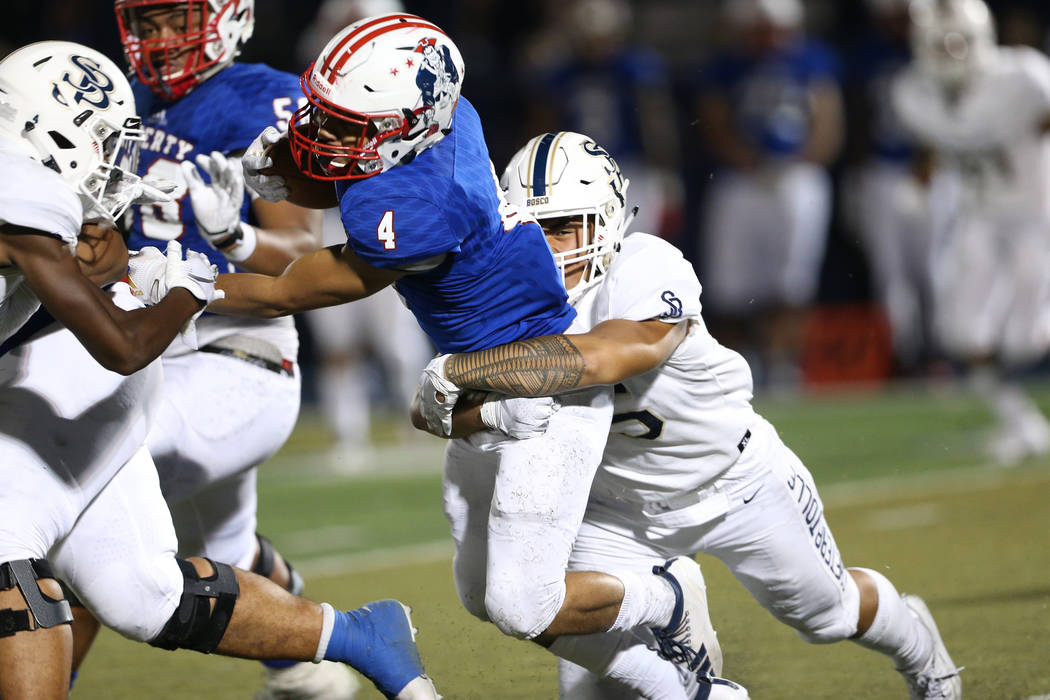 Liberty's Edward Gastelum (4) is tackled by St. John Bosco's Danny Lockhart (55) during the thi ...