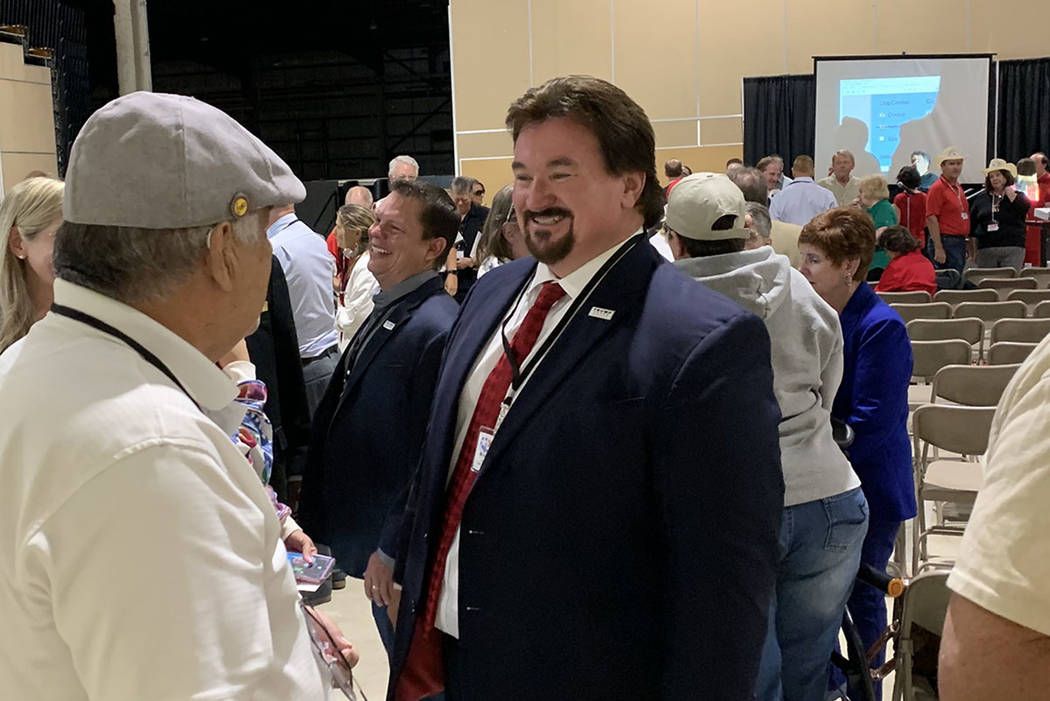 Nevada state GOP chairman Michael McDonald speaks to party delegates standing on line to vote f ...
