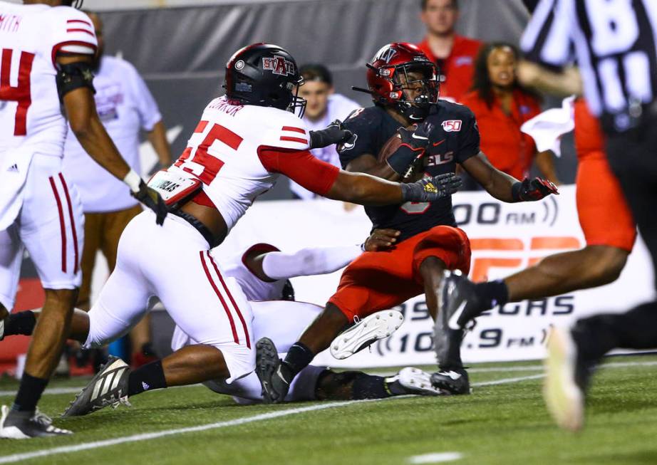 UNLV Rebels running back Charles Williams (8) tries to get past Arkansas State Red Wolves defen ...