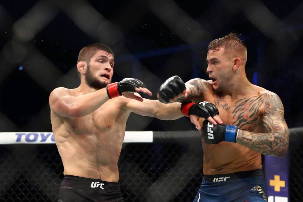 Russian UFC fighter Khabib Nurmagomedov, left, fights with UFC fighter Dustin Poirier, of Lafay ...