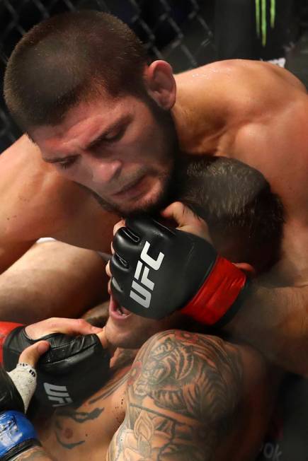 Russian UFC fighter Khabib Nurmagomedov, top, fights with UFC fighter Dustin Poirier, of Lafaye ...