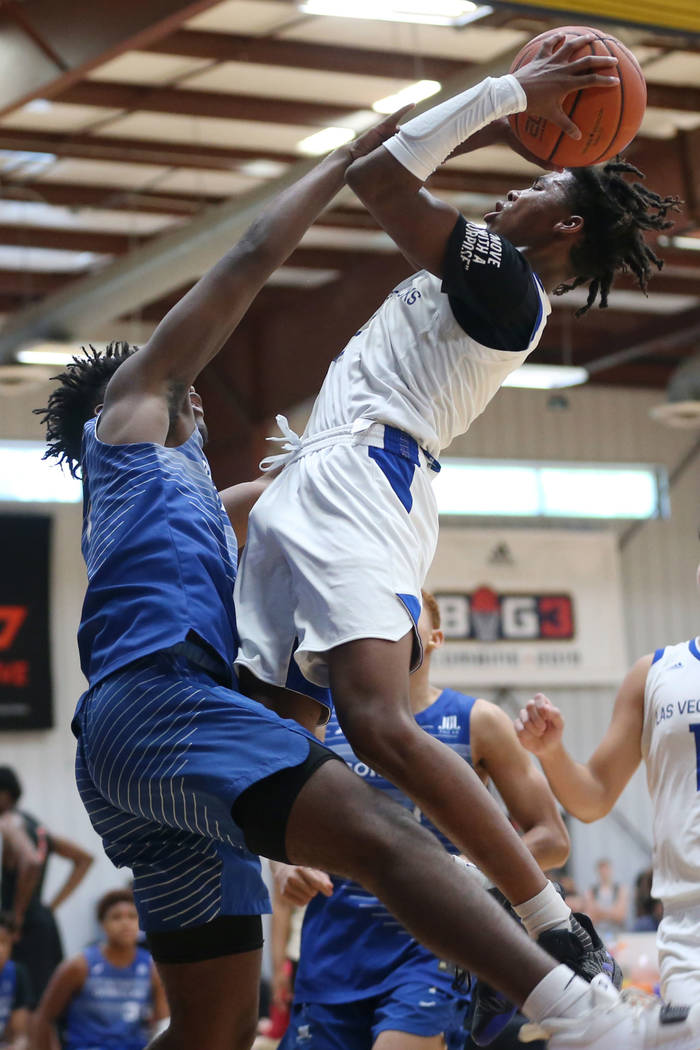 Las Vegas Knicks' Keshon Gilbert (3), right, takes a shot under pressure from U.T.U. Gorillas' ...