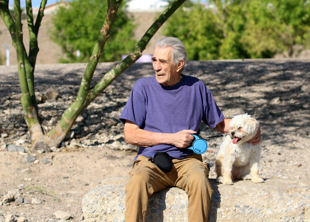 Don Bakkila of Henderson and his dog, Dilly, take a break from their morning walk at Cornerston ...