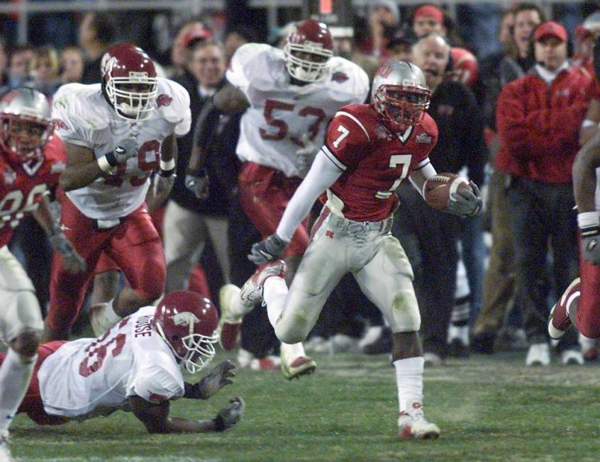 UNLV running back Jeremi Rudolph breaks a tackle by Arkansas defensive end Raymond House for a ...