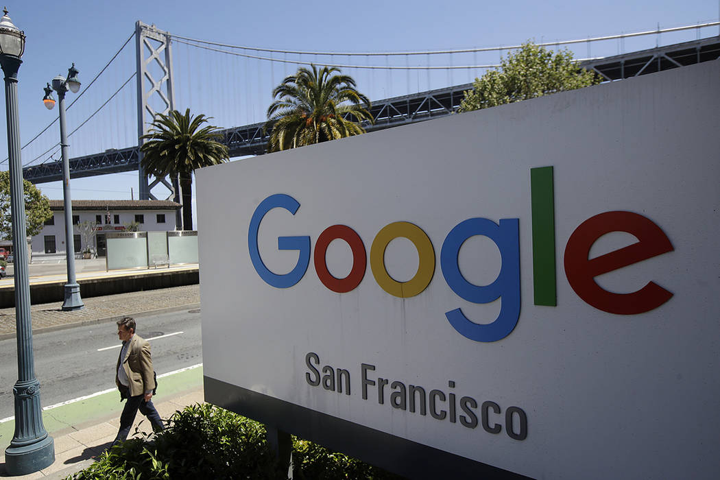FILE - In this May 1, 2019, file photo a man walks past a Google sign outside with a span of th ...