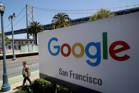 FILE - In this May 1, 2019, file photo a man walks past a Google sign outside with a span of th ...