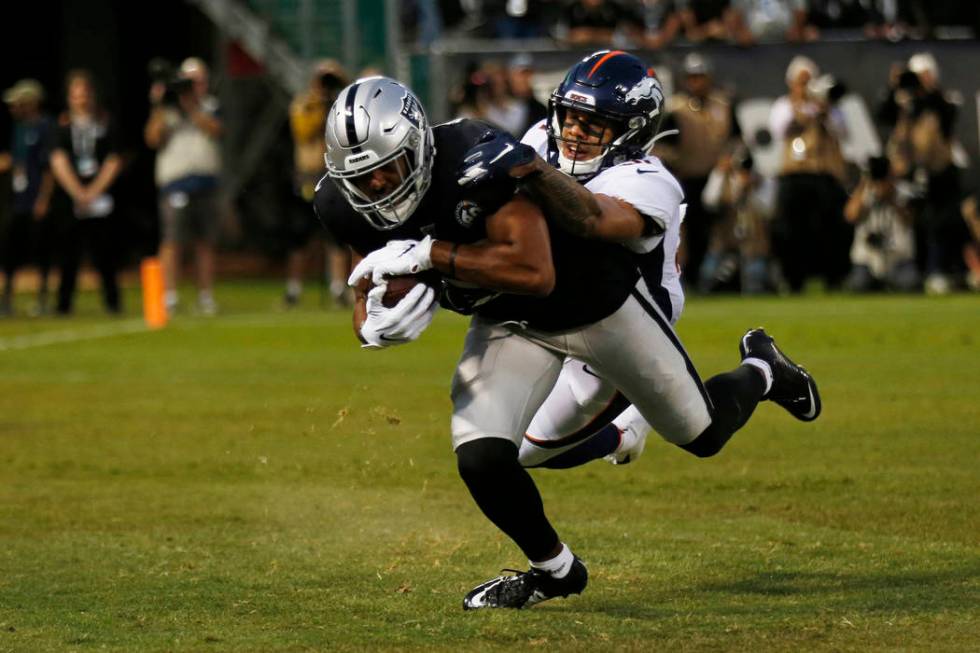 Oakland Raiders wide receiver Tyrell Williams scores a touchdown as Denver Broncos free safety ...