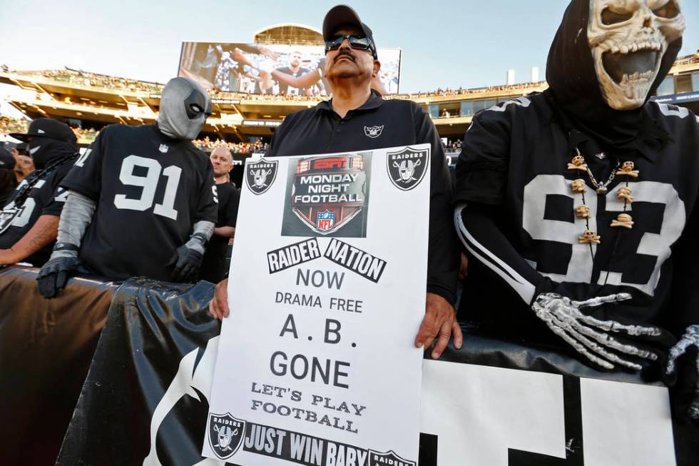 A fan holds a sign during the first half of an NFL football game between the Oakland Raiders an ...