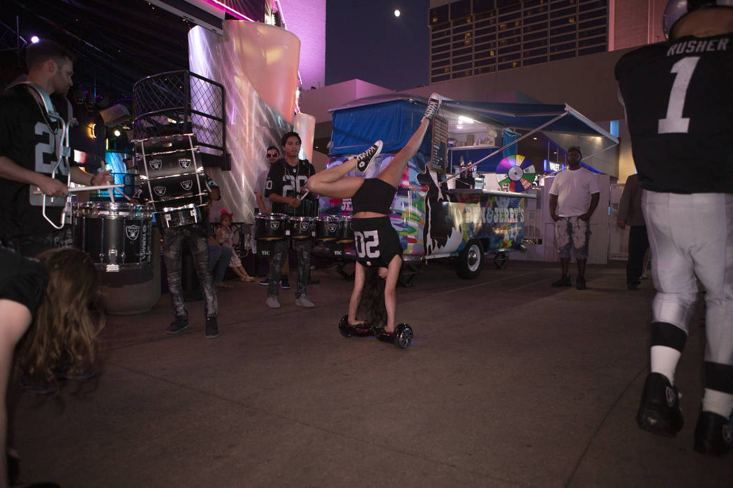 Diana Tatevossian, of Extreme Live Show, does a handstand on a hoverboard during a celebration ...