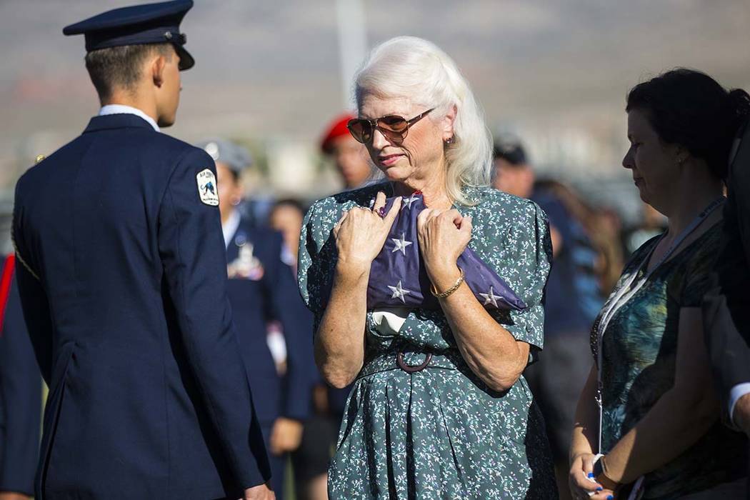 Retired teacher Gail Fahy holds the flag that was lowered and removed during the annual rededic ...