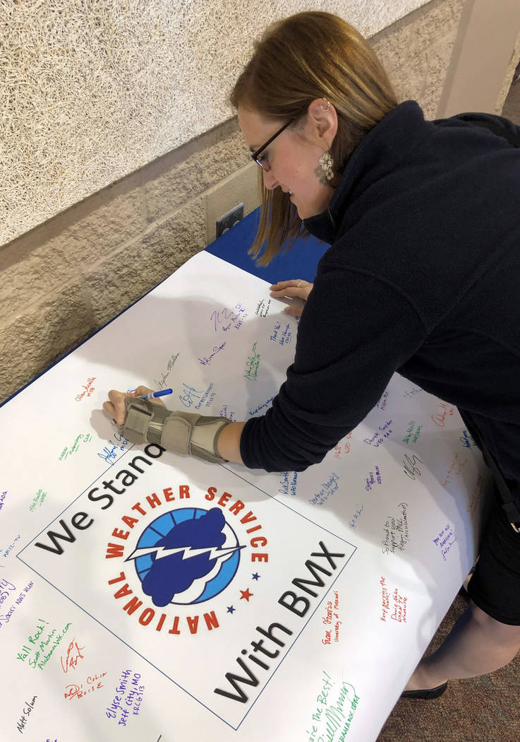 Christina Crowe signs a poster in support of the National Weather Service office in Birmingham, ...