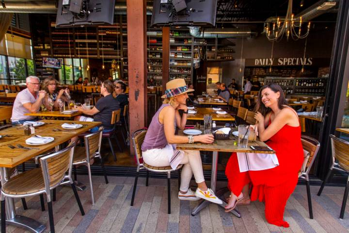 Customers Ryan Tselikis, center, and Olga McDowell, right, enjoy lunch on the deck at Grape Str ...