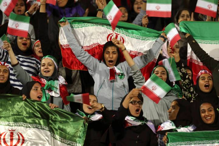 FILE - In this Oct. 16, 2018 file photo, Iranian women cheer as they wave their country's flag ...