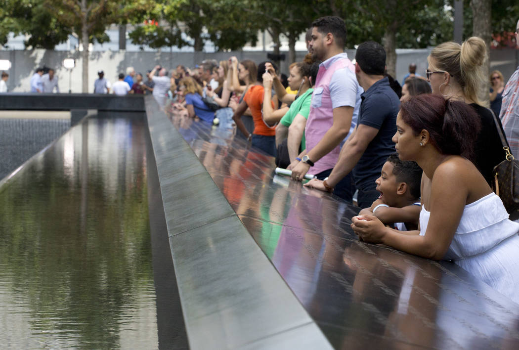 FILE- In this Sept. 9, 2015 file photo, visitors look at the waterfalls at the World Trade Cent ...
